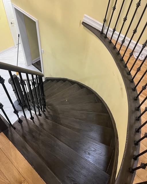 Curved staircase refinishing with iron spindles and dark oak treads, Brampton