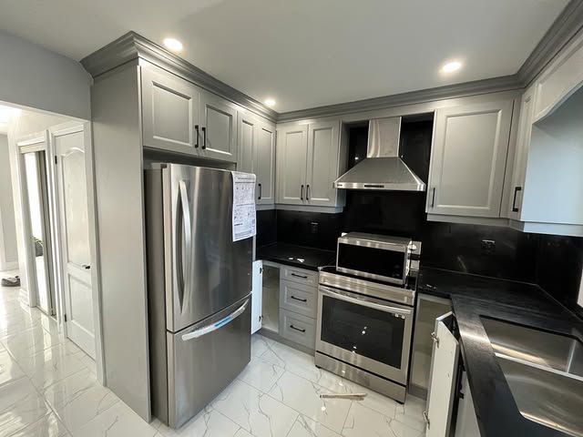 Kitchen renovation with stainless steel appliances and black granite countertops, Brampton