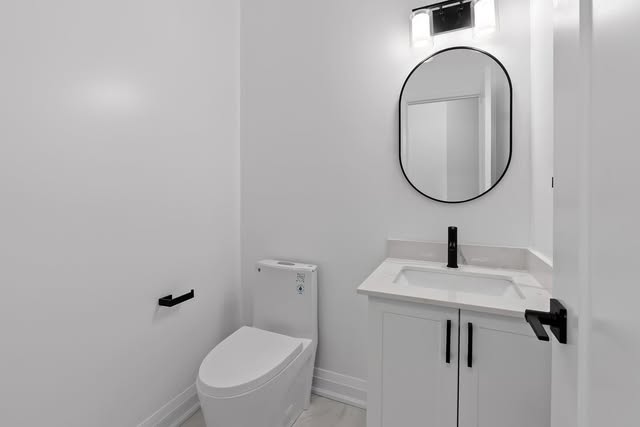 Powder room renovation with round mirror and matte black fixtures, Brampton